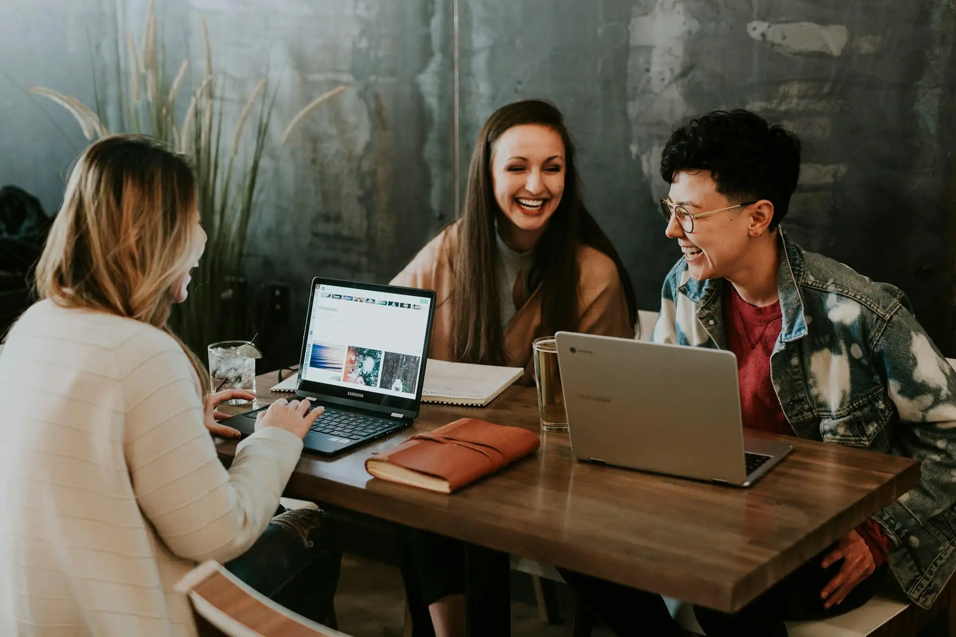 Colleagues working together at a table with laptops